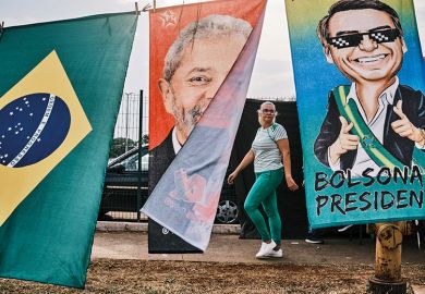 A woman walks by flags of Brazilian presidential candidates Luiz Inácio Lula da Silva and Jair Bolsonaro