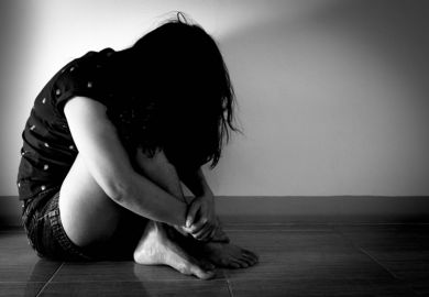 Trafficked woman sitting in the dark