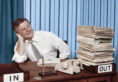 Office worker satisfied with full out tray and empty in tray on desk