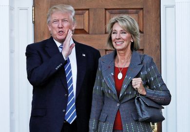 Donald Trump standing with Betsy DeVos