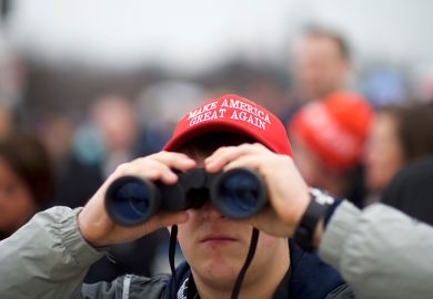 A Trump supporter wearing a MAGA hat looks towards the U.S. Capitol Building with binoculars during the inauguration of Donald Trump. To illustrate fears that Trump-backed overseers ‘will block scientific progress’