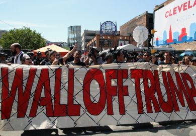 Cleveland, Ohio, USA - July 20, 2016: Participants in the 'Wall Off Trump' immigration march and rally demonstrate outside the Quicken Loans Arena, site of the Republican National Convention, on its third day. Cleveland, Ohio, USA - July 20, 2016: Participants in the 'Wall Off Trump' immigration march and rally demonstrate outside the Quicken Loans Arena, site of the Republican National Convention, on its third day.