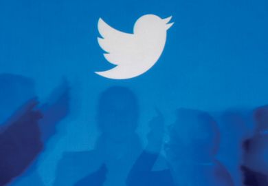 Twitter logo above silhouettes of people in discussion