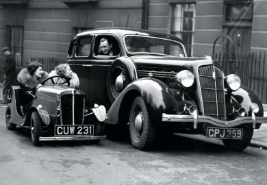 Women in small car looking at man in larger car Women in small car looking at man in larger car