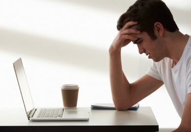 Unhappy male student looking at laptop