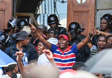 Chairperson of the University of the Free State student council, Pfarelo Maphangula, addresses students in front of the main building, 11 February 2025, South Africa. The group is demanding that students who owe money should be allowed to attend classes.