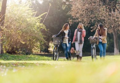 university students on green campus with bicycles to represent sustainability
