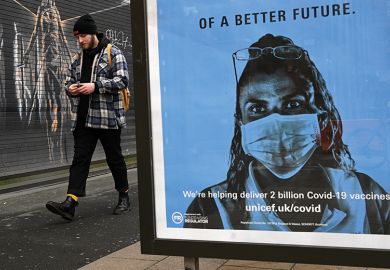 A pedestrian walks past a Unicef poster for Covid-19 vaccines, in Manchester, January 5, 2021, A pedestrian walks past a Unicef poster promoting Covid-19 vaccines, in Manchester, January 5, 2021, illustrating vaccine passports for campuses