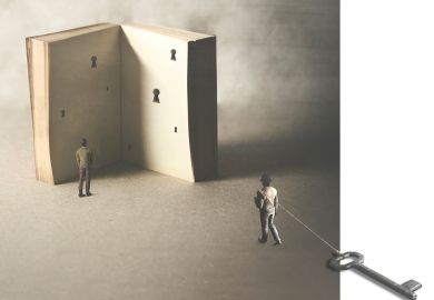 Concept illustration looking at a book with lock holes inside, one man is dragging a large key on a rope to illustrate Is mentoring the elixir of academic life?