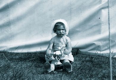 Unhappy child holding a winners cup to illustrate Teaching awards are  for losers, not winners