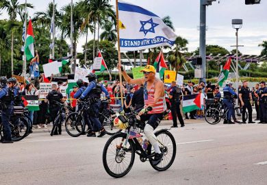 A pro-Israel protestor rides his bike along Biscayne Blvd A pro-Israel protestor rides his bike along Biscayne Blvd to illustrate US campuses confront extent of donor influence after Israel rows