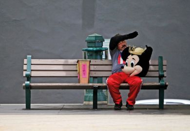 A street performer in a Mickey Mouse costume rests on a bench to illustrate We can’t stop the ‘rip-off degrees’ debate – but we can change its terms