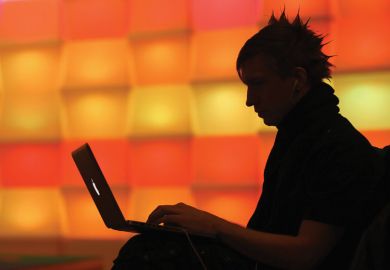 Man with laptop with bright orange background