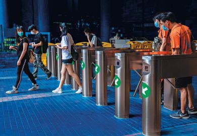 people walking through card operated turnstiles at the entrance to Hong Kong Polytechnic University to illustrate Lock out the inequities in global use of English 