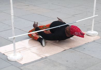 Person very low on ground under a limbo to illustrate the University of Liverpool against making redundancies based on research grant income and citation impact scores.