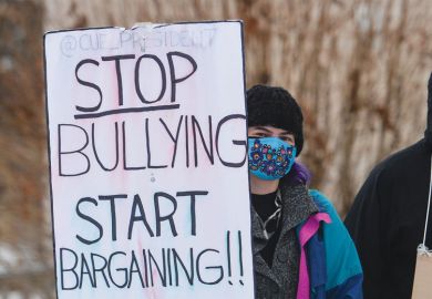 Protester holding banner while on strike over wage and workload disagreements in Edmonton, Alberta, Canada Protester holding banner while on strike over wage and workload disagreements in Edmonton, Alberta, Canada to illustrate Canadian campuses battle labour unrest and political meddling
