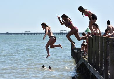 People jumping from a jetty into the sea in Southend-on-Sea, England People jumping from a jetty into the sea in Southend-on-Sea, England illustrate Value of domestic students almost halves at some UK universities