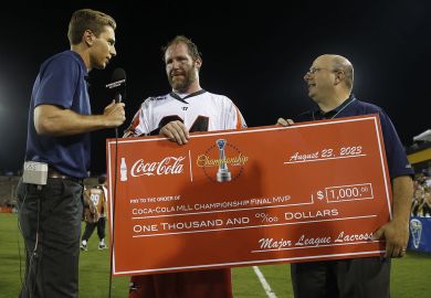  Major League Lacrosse Commissioner hands a check after the game in Kennesaw, Georgia to illustrate Most institutions lose out as US college sports professionalise