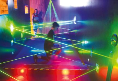 A visitor tries to walk through a security parcour out of laser motion sensors to illustrate HE ties to hacking ‘not surprising’
