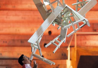 Chinese performer Guozhi Guo balances a stack of wooden trestle tables on his chin Weekend courses seek to give Chinese graduates employment edge