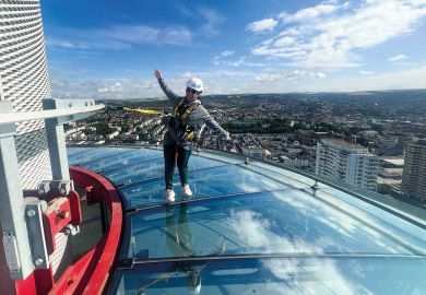  A visitor to British Airways i360 Viewing Tower in Brighton standing on the skywalk to illustrate TPS: universities seek respite from £125 million pensions bill