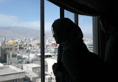 Woman looking out of a window in Tehran, Iran to illustrate ‘Blind growth’ of Iran’s universities ‘worsened’ high unemployment