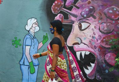 A pedestrian walks past a wall mural depicting a frontline medical staff stopping the Covid-19 as a metaphor for Research on viruses is  essential but can never be risk- free