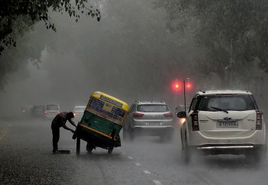 An Indian auto rickshaw driver tries to repair his vehicle after it broke down in heavy rain in New Delhi to illustrate Graduate unemployment emerges as Indian election issue