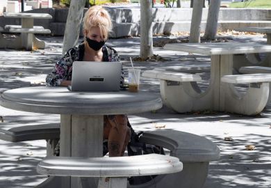 Student works on a laptop in a courtyard on campus to illustrate US students make gains in lawsuits over online teaching
