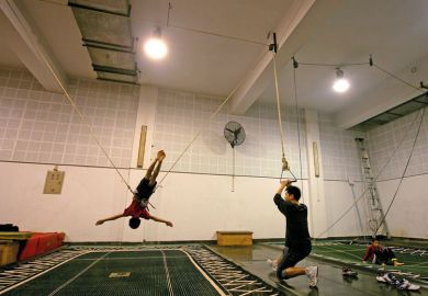 Person practices on a trampoline under the instruction of a coach to illustrate Probation period for PhD supervisors ‘could prevent exploitation’