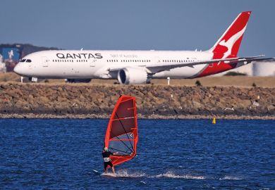 A sail boarder rides in front of a Qantas Airways plane to illustrate New Colombo Plan changes ‘will reverse equity gains’