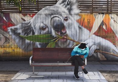 A man looks at his phone as he sits in front of a mural of a koala in Melbourne A man looks at his phone as he sits in front of a mural of a koala in Melbourne to illustrate Economic changes ‘slowing Australian students down’