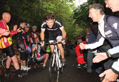 People cheering on man riding a bike as a metaphor for Incentivise staff to take part in innovation, universities told