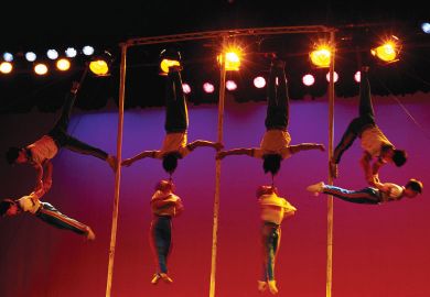 Acrobats linking arms in the air