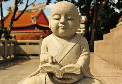 Statue of a Buddha reading at Kong Meng San Phor Kark See Temple in Singapore to illustrate What lessons can Singapore teach about lifelong learning