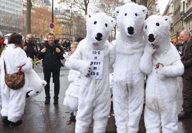 People wearing polar bear costumes are seen while activists stage a climate change demonstration near the Arc de Triomphe to illustrate Mandatory climate courses gain popularity, but challenges too