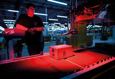 A man monitors the addressing process of a parcel inside an Amazon warehouse to illustrate Academics urge funding review after Toronto returns Amazon cash
