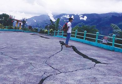 Person stands next to cracks in the ground at a park in Leyte province, central Philippines as a metaphor for the pan-regional university risks being split by the same tensions