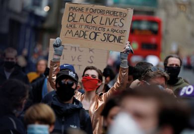 A protestor gestures during a demonstration called by the Rhodes Must Fall campaign