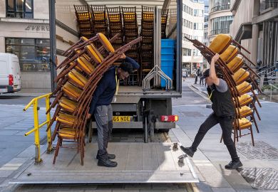 Contractors load tall stacks of event chairs into the company lorr to illustrate English university severances top £100m