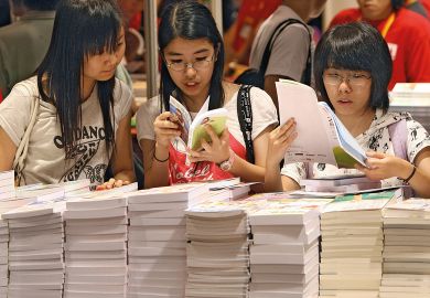 Visitors browse books on the first day of opening of book fair to illustrate Universities seek to overcome Chinese open access resistance
