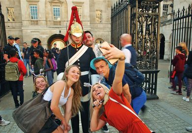 King's guard stands to attention guarding the entrance to the Horse Parade while tourists take a selfie King's guard stands to attention guarding the entrance to the Horse Parade while tourists take a selfie to illustrate Age of the influencer?