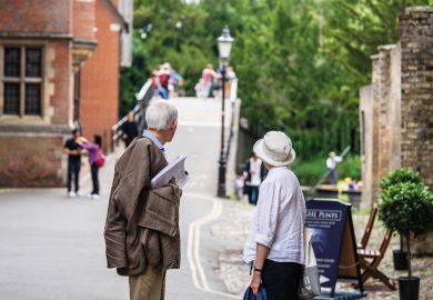 Elderly couple walking down the street in Cambridge to illustrate ‘Forced retirement’ rules face new challenge at Cambridge