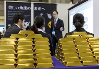 University students listen to a company recruiter at a job fair at Tokyo to illustrate Japan seeks to improve salary prospects for PhD graduates
