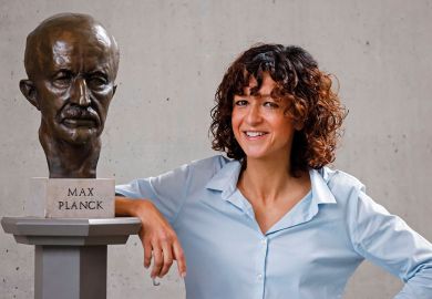 French researcher in Microbiology, Genetics and Biochemistry Emmanuelle Charpentier poses for photographers next to a bust of Max Planck in Berlin as described in the article