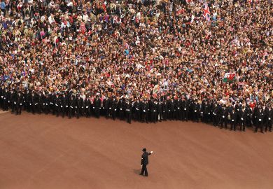 Well wishers surge along the Mall behind the police towards Buckingham Palace to celebrate the Royal Wedding of Prince William to illustrate Should student number caps be reinstated in England?