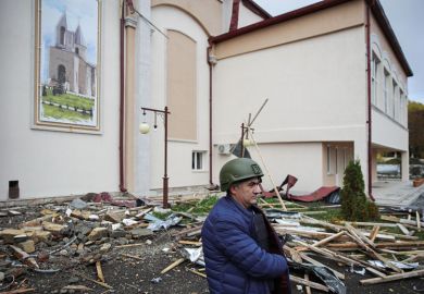 A man stands outside the House of Culture damaged by Azerbaijani military strikes  for Concern over Azerbaijan ruling family influence at Oxford centre