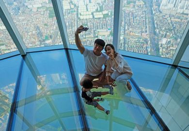 A Korean family taking selfie photo at the glass floor observatory of Lotte World Tower  for Top Korean universities more ‘glass floor’ than ‘social ladder’
