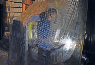 A man looking for books at a book store in a curtain  in the Jinbocho area in Tokyo to illustrate More awareness of open access needed as Japan deadline looms