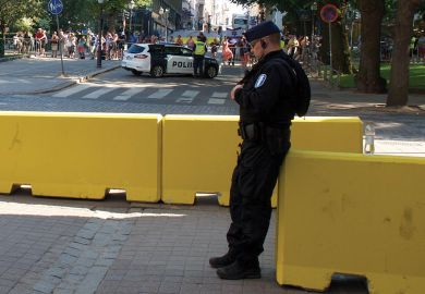 Finland policeman on duty leaning on a barrier Finland police on duty leaning on a barrier as a metaphor for Academics reluctant to report violent online threats to police